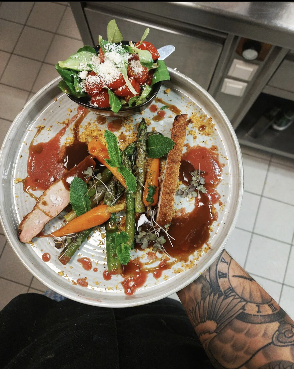Plated course with asparagus, young carrots and herbs